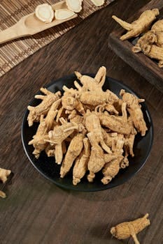 High angle view of fresh ginseng roots on a black plate on a wooden table, showcasing the natural texture and earthy tone of Ginseng roots, one of the main Chinese Herbs for weight loss.